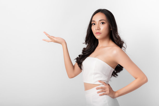 有吸引力的美丽亚洲女性在时尚的肖像与微笑的面孔穿着白色的裙子在白色的背景化妆或保健图片下载