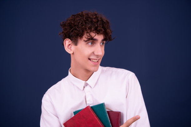 惊讶的年轻迷人的学生正在看书。图片下载