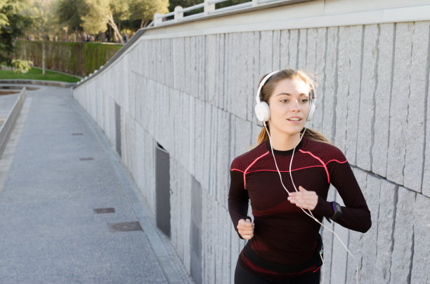 健康快乐的女人慢跑跑步户外听音乐图片下载