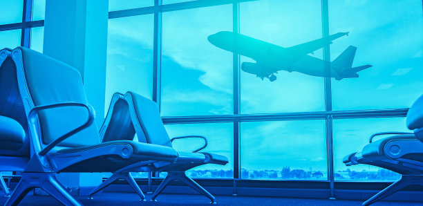 在候机厅的乘客座位上看飞机，从机场候机楼看。阳光以蓝色的颜色选择焦点，交通和旅行的概念图片下载