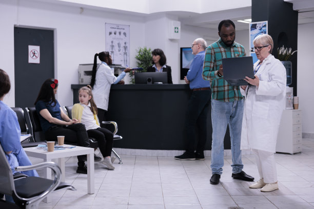 年长医生拿着笔记本电脑，里面有化验结果，正在和非裔美国病人交谈图片下载