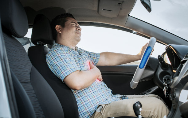 开车时胸部疼痛的男司机。开车时心脏病发作的人。司机胸痛。司机心脏病发作的概念，患有胸痛的司机图片下载