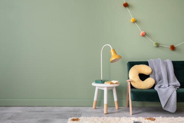 创意构成时尚和舒适的儿童房室内设计，绿色墙壁，瓶绿色沙发，毛绒枕头，明亮的地毯，灰色格纹和凳子的配件。副本的空间。模板。图片下载