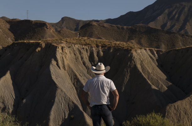 沙漠里戴牛仔帽的成年男子。西班牙阿尔梅里亚图片下载