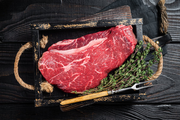 未烹饪的牛臀肉或生牛腰肉牛排。黑色木质背景。顶视图图片下载