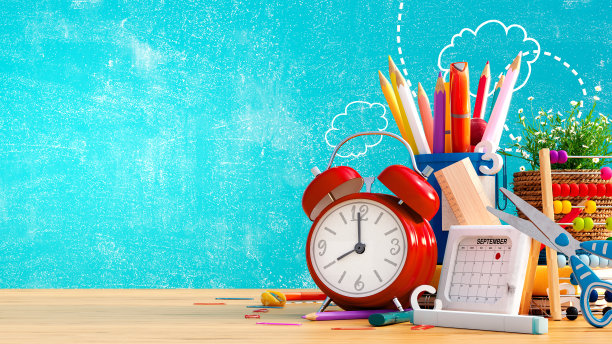 准备上学，回到学校的概念。闹钟与铅笔和学校配件在蓝色的黑板背景图片下载