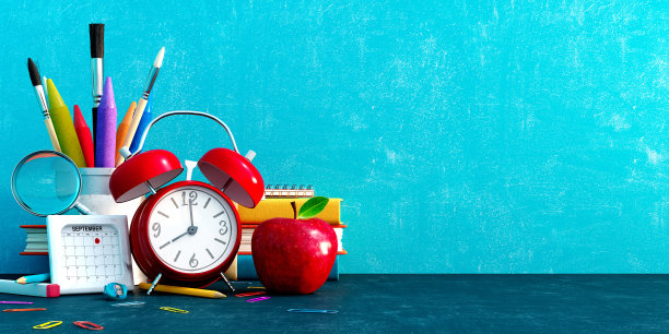 准备上学，回到学校的概念。闹钟与铅笔和学校配件在蓝色的黑板背景图片下载