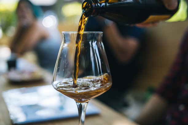 把蜂蜜酒倒进桌上的玻璃杯里图片下载