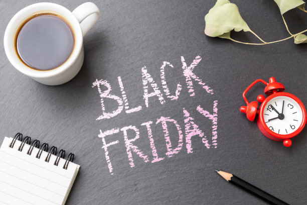 黑色星期五销售的概念与咖啡杯和树叶在黑色的石头桌上图片下载