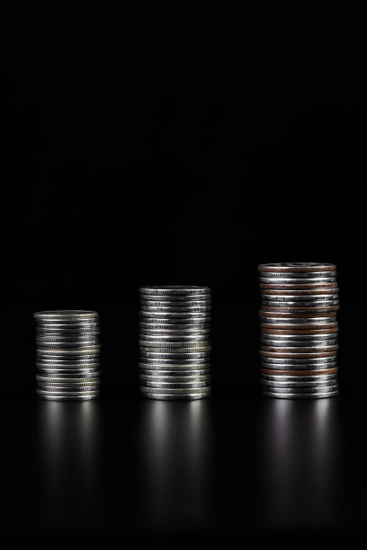 深色背景下成堆的金属硬币图片下载