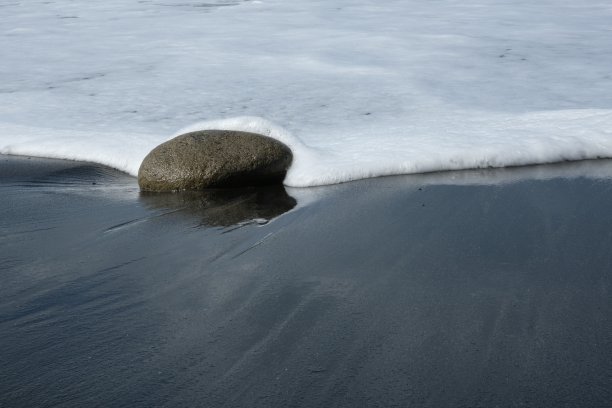 沙滩上的卵石被海浪扫过图片下载