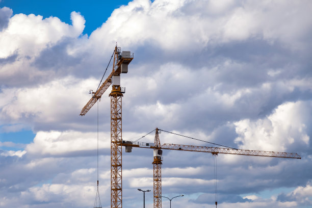 工业起重机的底视图。在蓝天背景的创作现场施工吊车。公寓建筑建设与住宅改造的概念。本空间图片下载