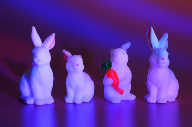 红色背景的玩具兔子。明亮的彩色背景。图片下载