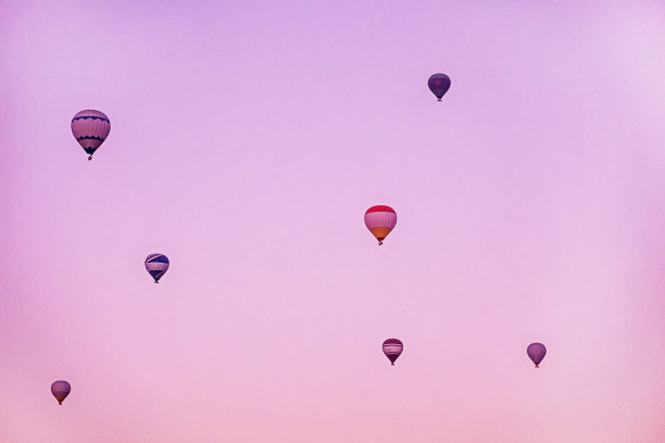 日出前，热气球在粉红色的天空中飞行图片下载