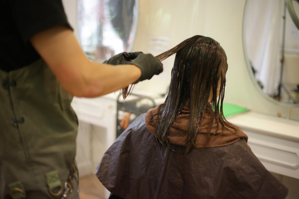 男理发师给女人的头发涂药图片下载