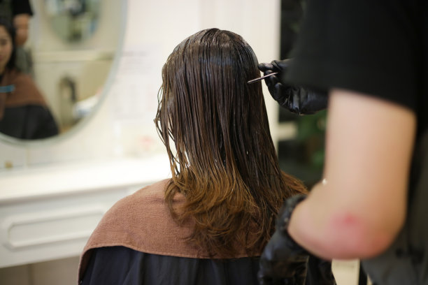 男理发师给女人的头发涂药图片下载
