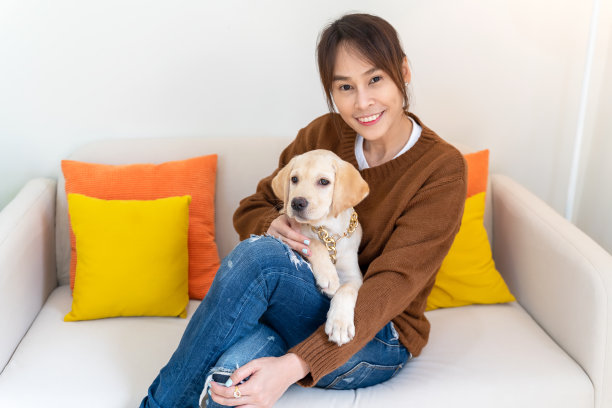 年轻的亚洲女子与可爱的小狗狗和主人在家里的客厅一起度过了愉快和放松的时光。女性和宠物喝咖啡的友谊。生活方式的概念图片下载