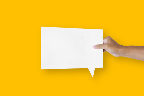 手里拿着一个方形的白纸气球，黄色背景上孤立着语音气泡和通信气泡图片下载