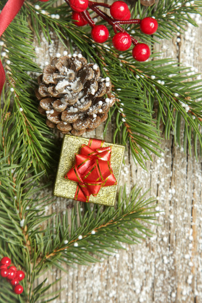 圣诞树的树枝，礼盒，针叶树球果和红色浆果顶视图复制空间在旧的木制背景。圣诞节，寒假，新年的概念。图片下载