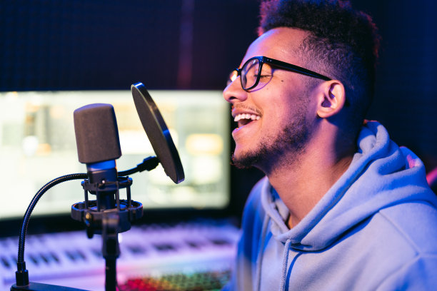 年轻男歌手在录音棚霓虹灯下表演图片下载