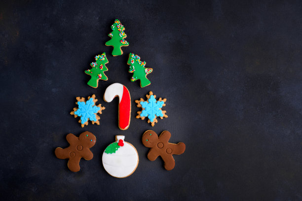 在黑暗的背景上，各种各样的圣诞树形状的圣诞饼干图片下载
