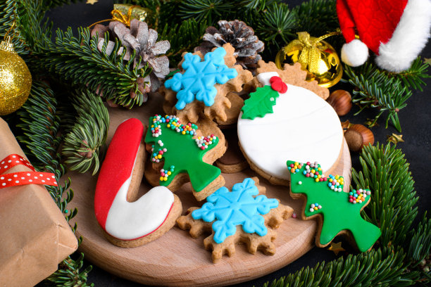 圣诞姜饼饼干，糖糊和天然冷杉树和圣诞装饰在黑暗的背景图片下载