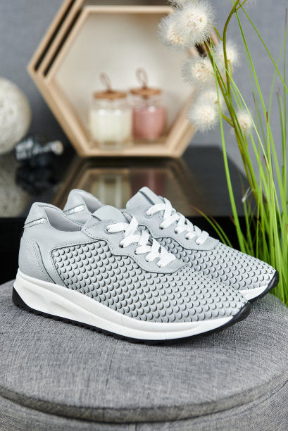 时尚的灰色女鞋在灰色的绒毛背景在商店，复制空间。新运动鞋，特写。美丽和时尚的概念。图片下载