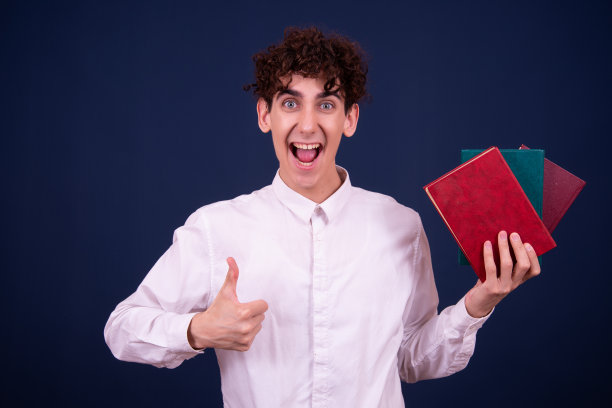 惊讶的年轻迷人的学生正在看书。图片下载