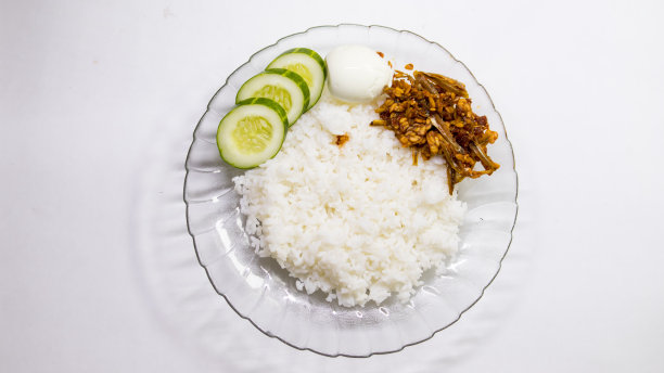 坎普尔Nasi Campur，配菜是炸凤尾鱼和三片黄瓜，背景是白色的图片下载