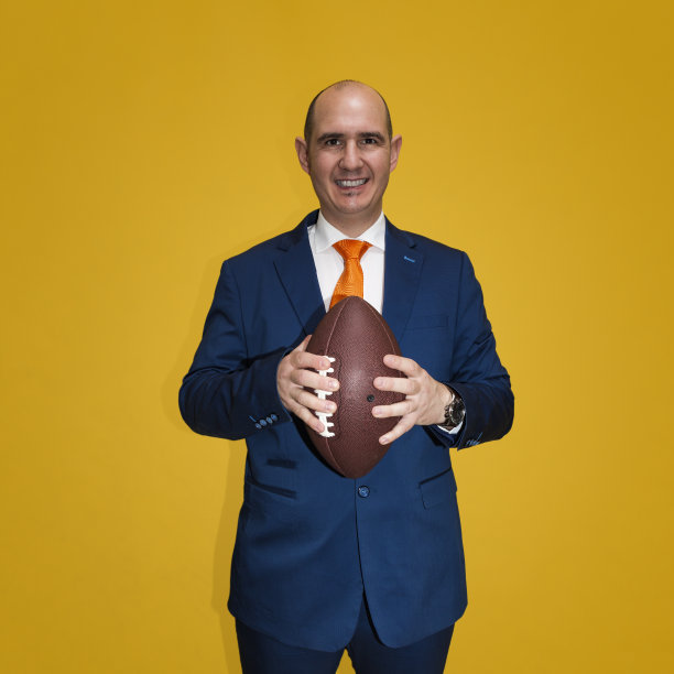 秃头男子拿着美式橄榄球图片下载