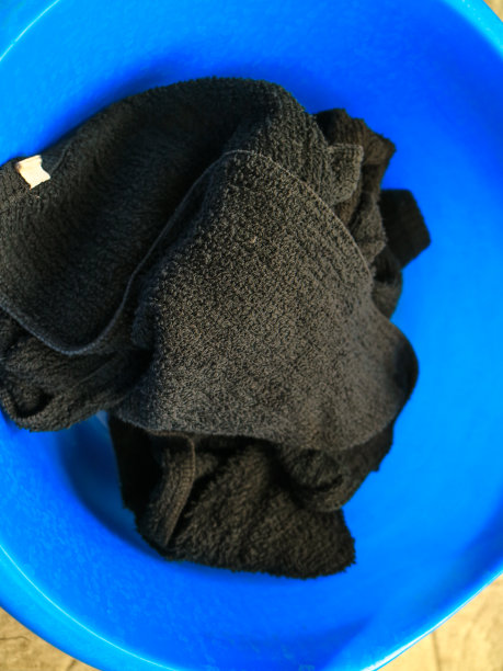脏黑毛巾放在蓝盆里。图片下载