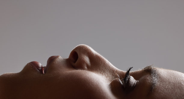 特写面对美丽的女人光滑，柔软和健康的皮肤在工作室背景。迷人的、时髦的、前卫的模特头像，自然的睫毛和抗衰老的护肤化妆品图片下载