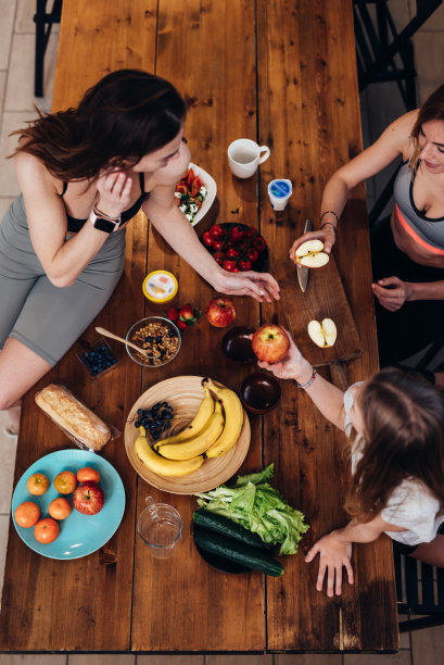 零食时间，运动女孩坐在餐桌旁图片下载