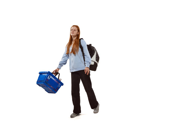 年轻的女孩，学生去购物，拿着大购物篮孤立在白色背景图片下载