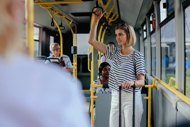 白人妇女带着旅行箱乘坐穿梭巴士旅行图片下载