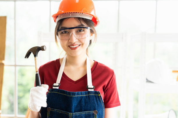 靠近年轻的女木匠拿着钢悍马在木工车间。家具作坊里的女工画像图片下载