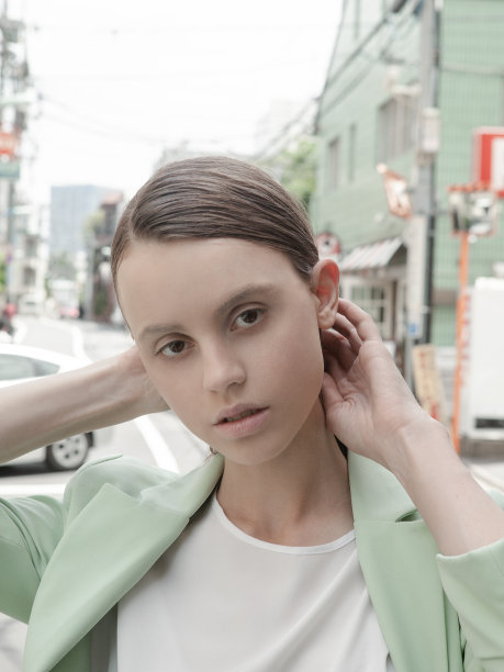 美丽的年轻女子穿着白色超大衬衫方格百褶裙和金色耳环在东京街头模特户外肖像在日本的时尚灵感图片下载