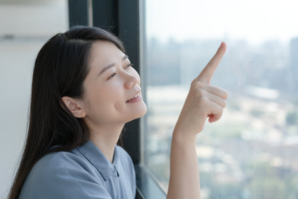 女人看着窗户，指着什么东西图片下载