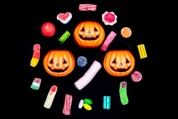 被糖果包围的万圣节南瓜。甜食,糖。亡灵节。假期,万圣节。图片下载