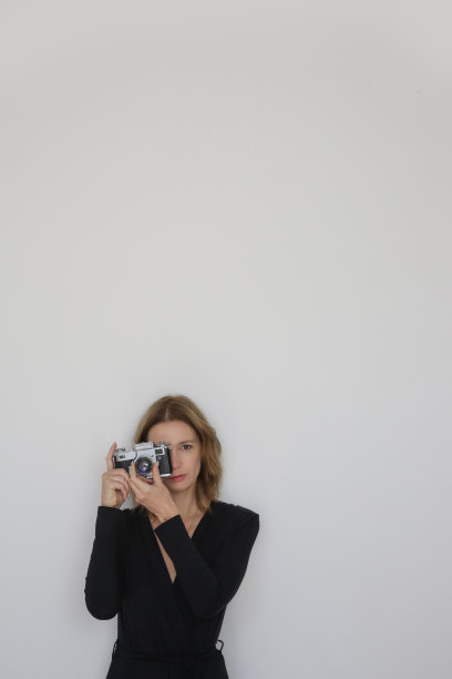 系列工作室照片的年轻女模特在黑色粘胶裹裙手持复古卡马拉。图片下载