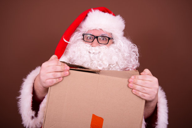 交付。滑稽的圣诞老人拿着空盒子。图片下载
