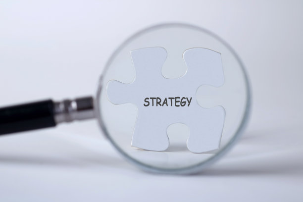 战略字与手握放大镜上方的拼图图片下载