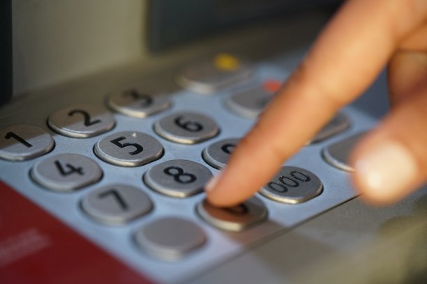 手在自动柜员机输入PIN码的特写图片下载