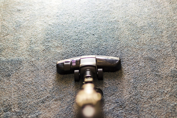 灰色地毯上的真空吸尘器照片，家务图片下载