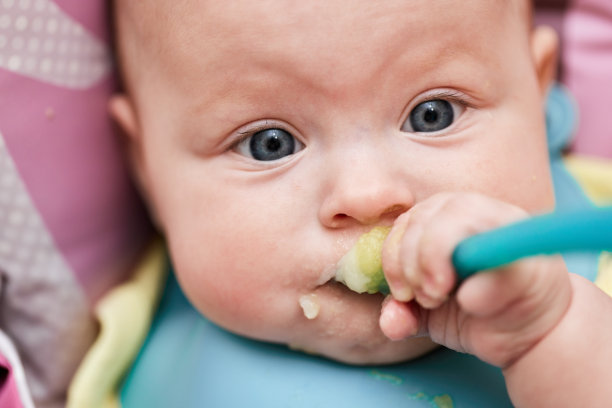 可爱的小女孩在厨房用勺子吃饭图片下载