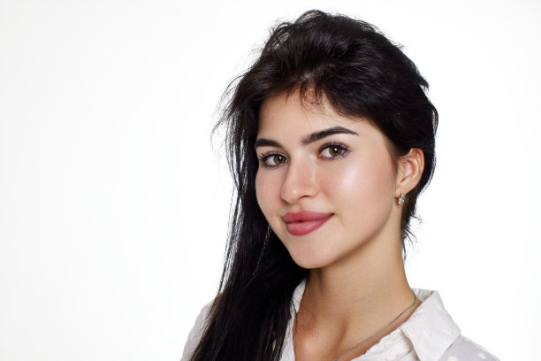 美丽的褐发年轻女子，身穿白色衬衫，面带微笑图片下载