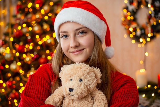 戴着圣诞帽和泰迪熊的漂亮少女图片下载