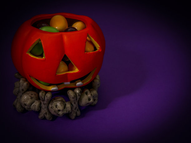 陶瓷万圣节南瓜与糖果在紫色的背景。图片下载
