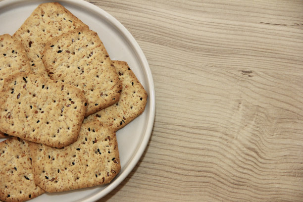 干的方形减肥饼干与黑孜然种子和藜麦放在装饰玻璃盘图片下载