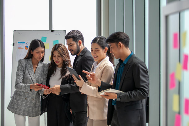 业务团队男女同事在工作中交谈，手中拿着数据报告，分享想法，快乐的同事在办公室一起工作。图片下载